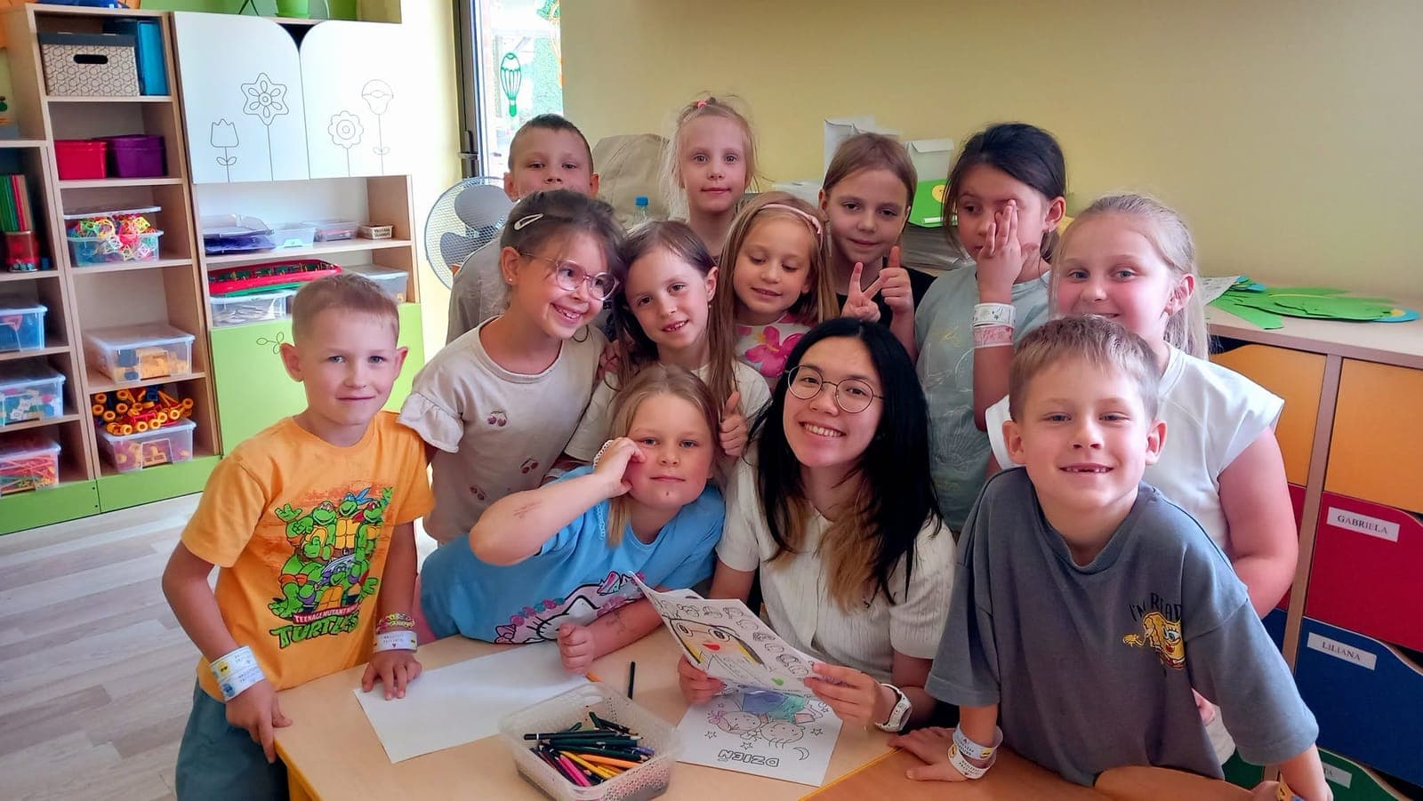 A class selfie of an exchange participant with a group of smiling children