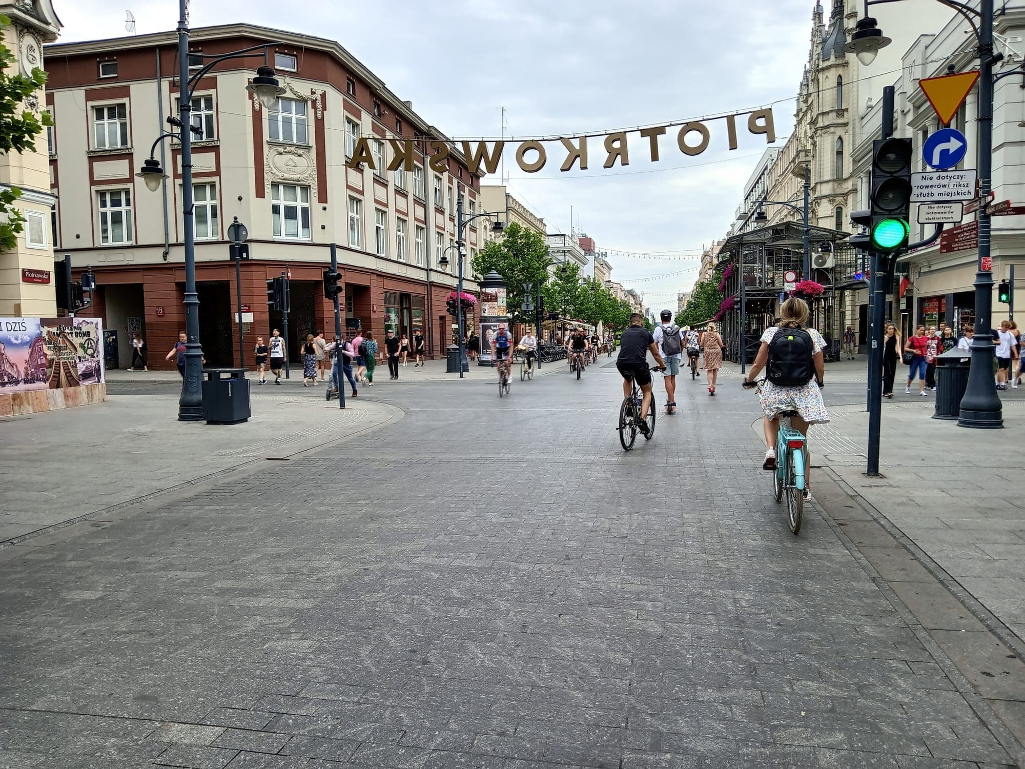 People cycling and walking along Piotrkowska Street in Łódź